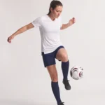 Woman wearing the white Ladies Hawk Evolution Soccer Jersey while controlling a soccer ball.