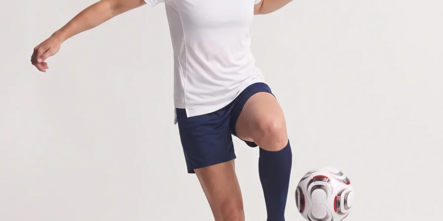 Woman wearing the white Ladies Hawk Evolution Soccer Jersey while controlling a soccer ball.